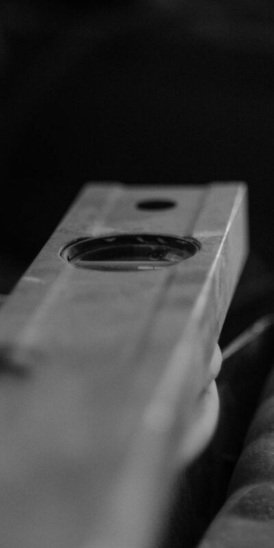 Black and white image of construction tools in a workshop, emphasizing a spirit level.