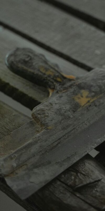 Close-up of a spatula and duct tape on an aged wooden surface. Perfect for DIY and renovation themes.