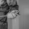 Monochrome photo featuring a worker's hand gripping a wrench, symbolizing construction.